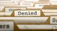File drawer with one folder in focus, labeled "Denied" [Image by creator tashatuvango from AdobeStock]